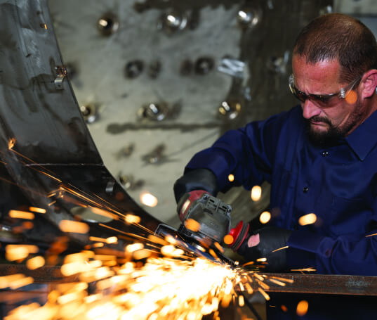 VESCO A company of the BUSCH Group A VESCO team member wearing a blue shirt and doing some welding work