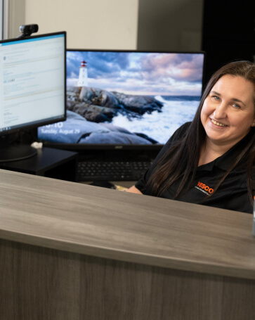 A VESCO team member woman sitting at a desk with a mug in front of her